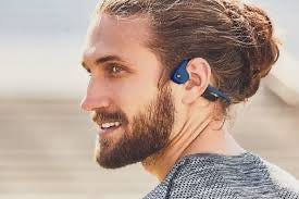 Man wearing a wireless New Real Bone Conduction Sport Headphones with a blurred natural background