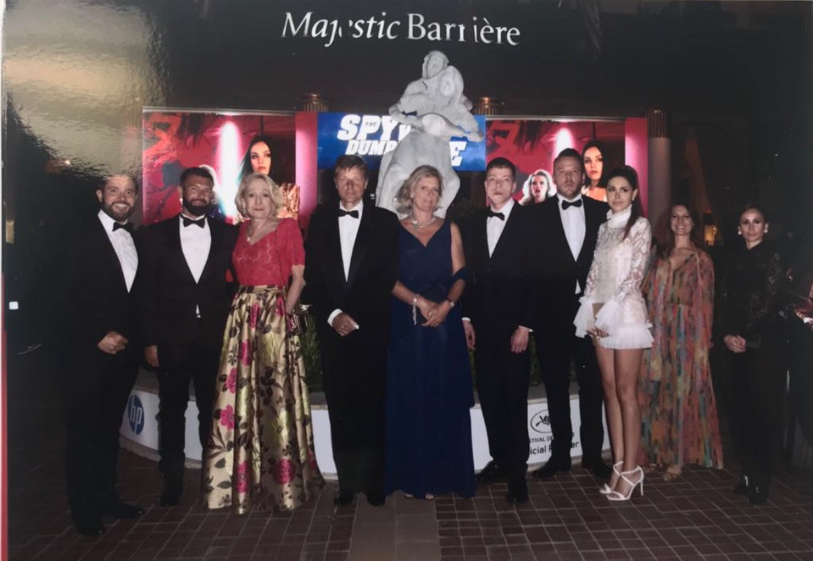 Group of formally dressed people posing in front of a 'Majestic Barriere' Festival de Cannes - France